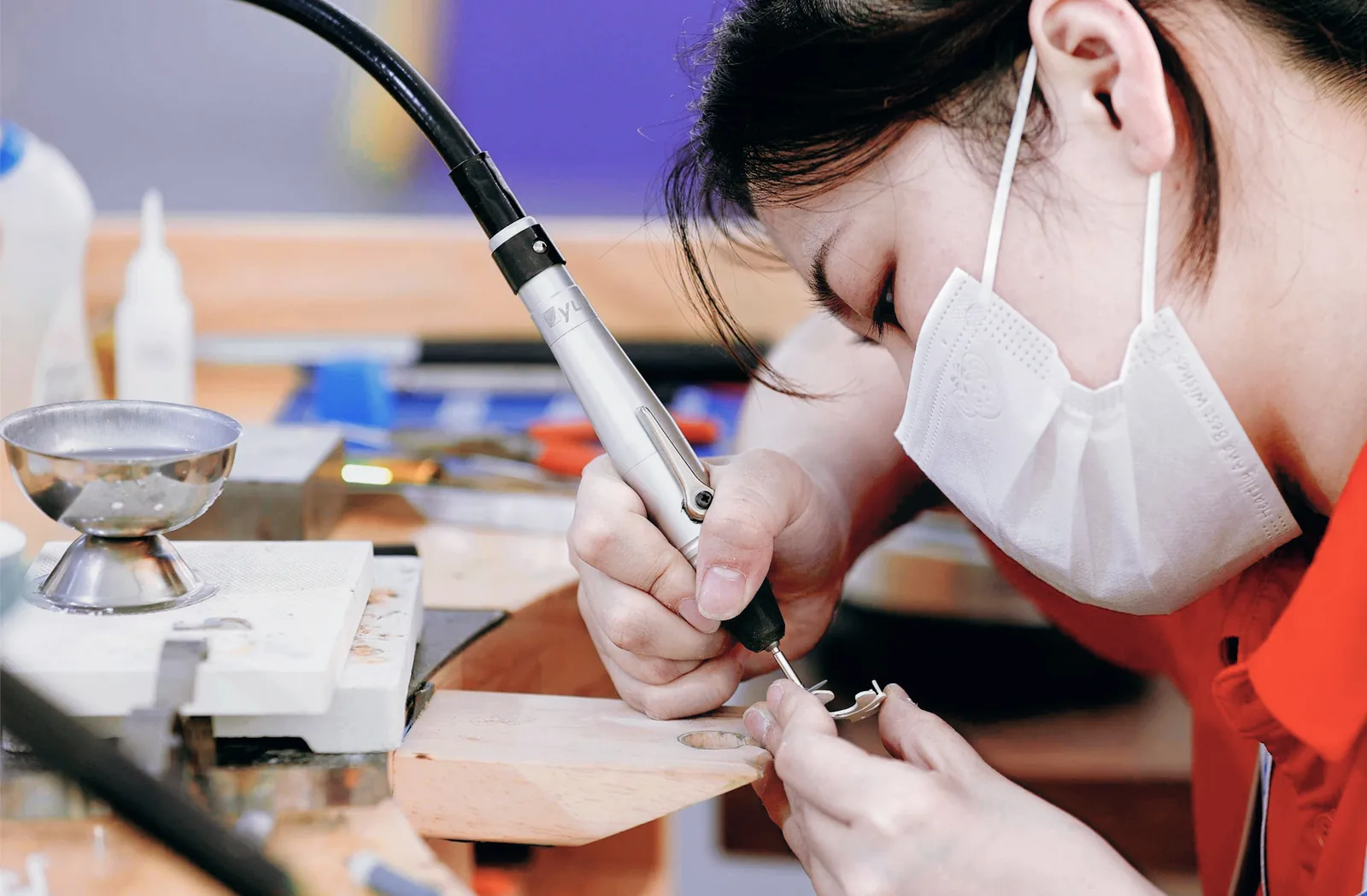 Jewelry craftsperson refining a piece at the bench